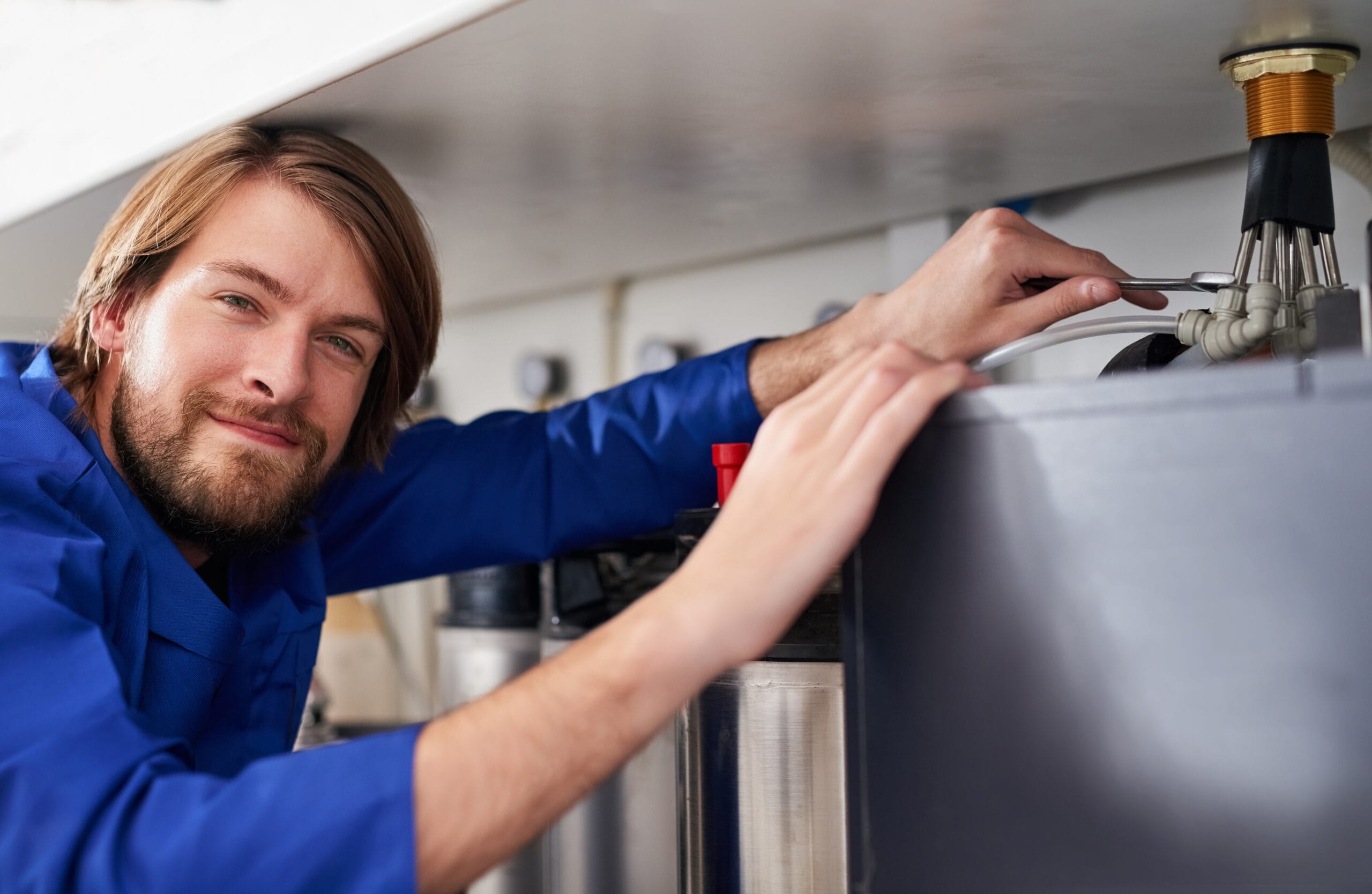 Technician servicing a residential water heater tank in Citrus Heights